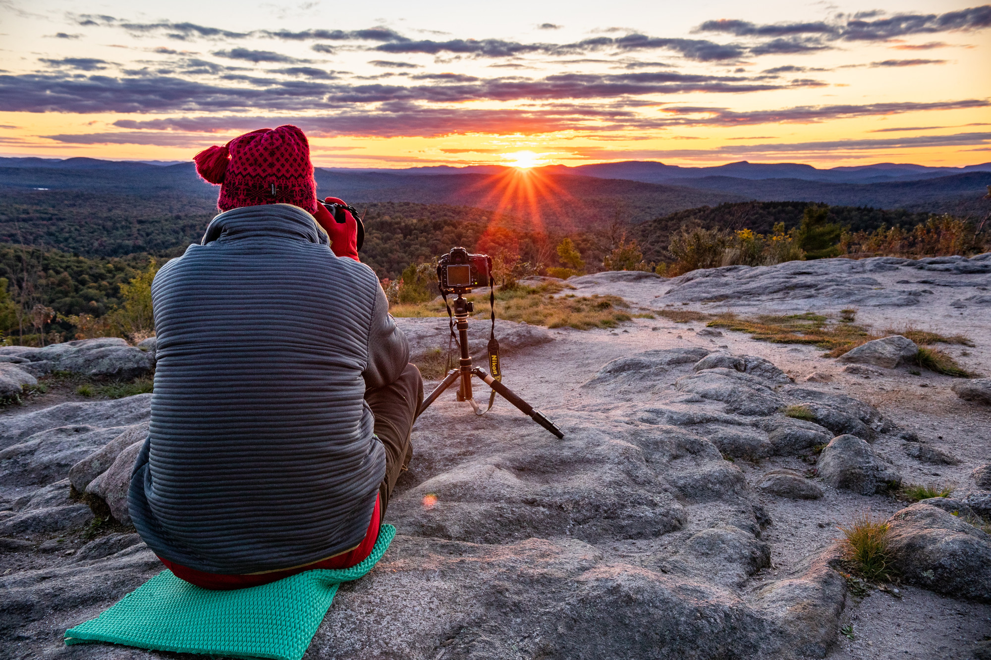 A hiker watches the sun set on Coney Mountain, New York.