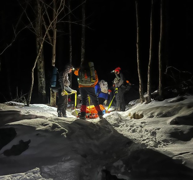 Rescuers prepare to carry an injured person in a litter during a rescue on Monadnock in January 2024. Over the weekend, rescuers had to navigate challenging terrain to transport an injured climber in a litter to safety. (NH Fish and Game Photo)